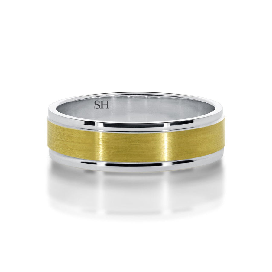 Men's two tone wedding band with central satin finish R12-077B-W0110. This classic 18k yellow and white gold men's wedding ring has polished white gold rounded edges with a yellow gold flat centre profile and a satin finish applied. The ring has an overall subtle look with a beautiful contrast from the reflective polished edges. The ring has a wide uniform width and a bold solid feel to it.